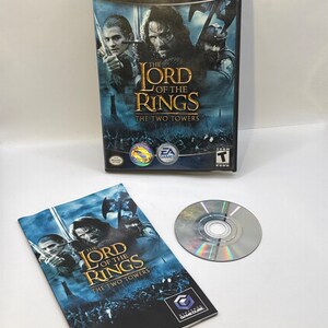 May include: A Nintendo GameCube video game, "The Lord of the Rings: The Two Towers." The game case, instruction booklet, and disc are visible. The case features a movie poster-style image with characters and the game title.