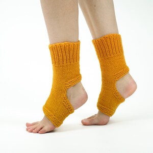 May include: A pair of mustard yellow knitted ankle socks with an opening at the heel. The socks are made of a soft, comfortable material and are perfect for yoga or Pilates.