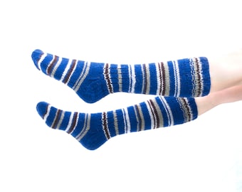May include: A pair of blue and white striped socks with brown accents. The socks are made of a soft, knitted material.