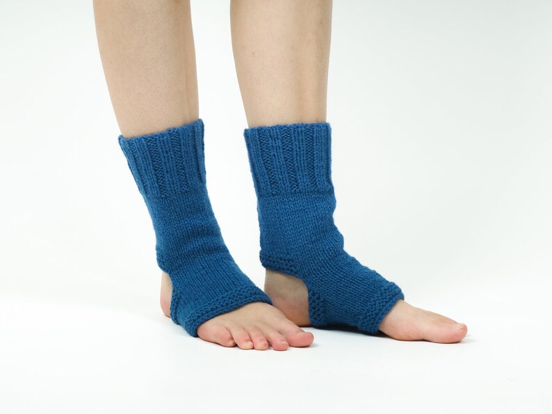 May include: A pair of blue knitted ankle warmers with an opening for the heel. The warmers are made of a soft, stretchy material and are perfect for keeping your feet warm in the winter.