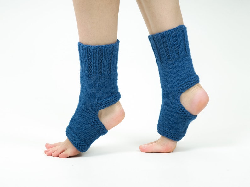 May include: A pair of blue knitted ankle warmers with an opening at the heel. The warmers are made of a soft, textured yarn.
