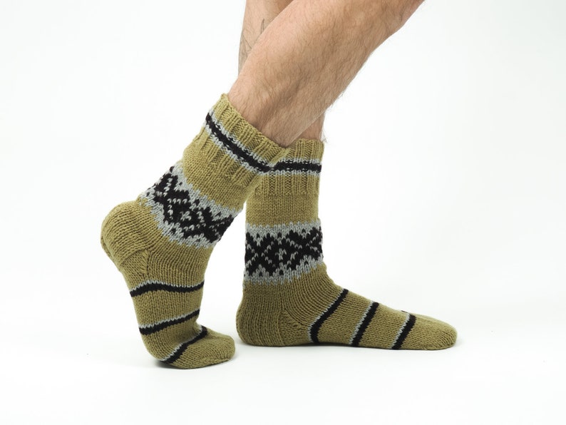 May include: A pair of brown and black patterned socks with a grey stripe. The socks are made of a soft, knitted material.
