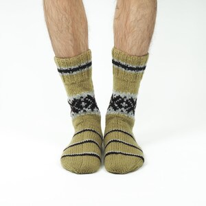 May include: A pair of beige socks with black and grey stripes and a geometric pattern. The socks are made of a soft, knitted fabric.