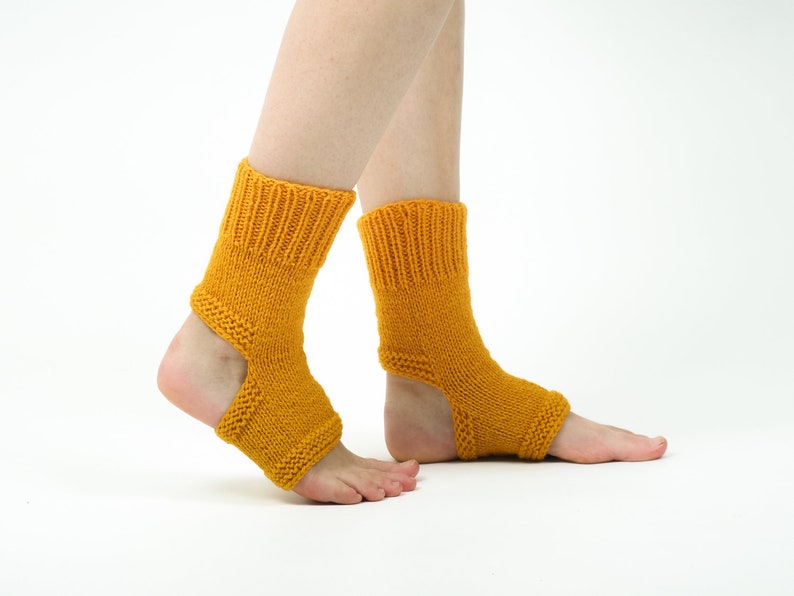 May include: A pair of yellow knitted ankle socks with an opening at the heel. The socks are worn on a person's feet.
