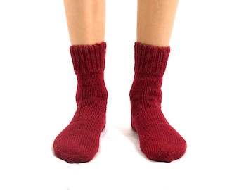 May include: A pair of red knitted socks.