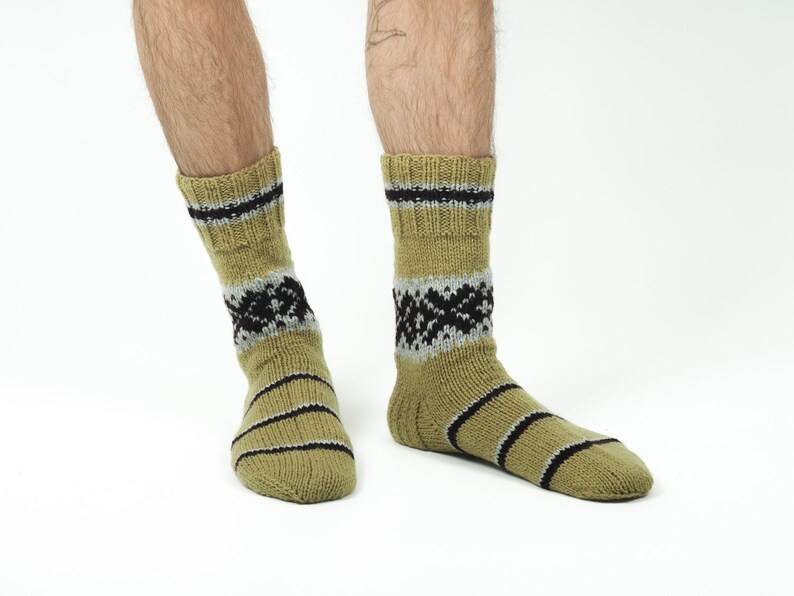 May include: A pair of green and black patterned socks with a striped design.