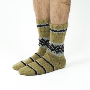 May include: A pair of olive green socks with black and gray stripes and a geometric pattern. The socks are made of a soft, knitted fabric.