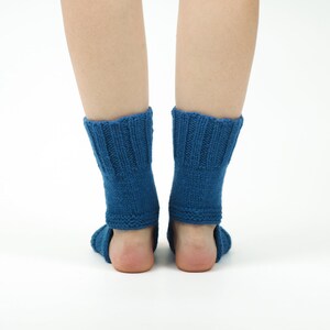 May include: A pair of blue knitted ankle socks with a ribbed pattern. The socks are worn on a person's feet.