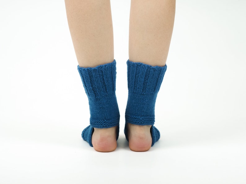 May include: A pair of blue knitted ankle socks with a ribbed pattern. The socks are worn on a person's feet.