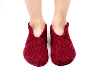 Può includere: Un paio di calzini da pantofola in maglia color borgogna. I calzini sono realizzati in un materiale morbido e caldo e hanno una vestibilità comoda.