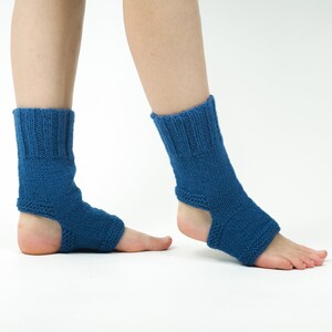 May include: A pair of blue knitted ankle warmers with an open heel design. The warmers are made of a soft, comfortable material and are perfect for keeping your feet warm in the winter.