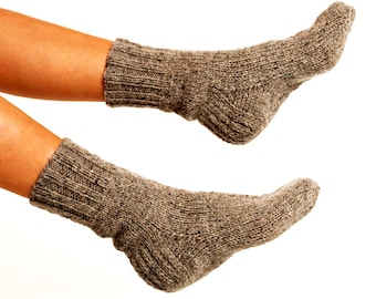 May include: A pair of brown wool socks with a ribbed texture. The socks are worn on a person's feet.