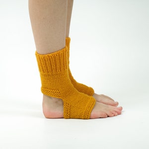 May include: A pair of yellow knitted ankle socks with an open heel design. The socks are made of a soft, comfortable yarn and are perfect for keeping your feet warm in the cooler months.