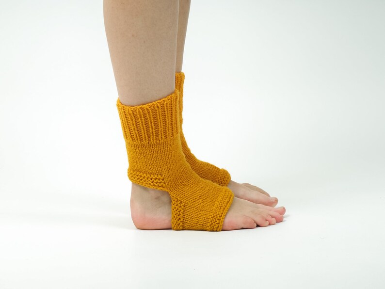 May include: A pair of yellow knitted ankle socks with an open heel design. The socks are made of a soft, comfortable yarn and are perfect for keeping your feet warm in the cooler months.
