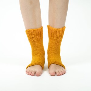 May include: A pair of yellow knitted ankle socks with open toes. The socks are made of a soft, warm material and are perfect for keeping your feet warm in the winter.