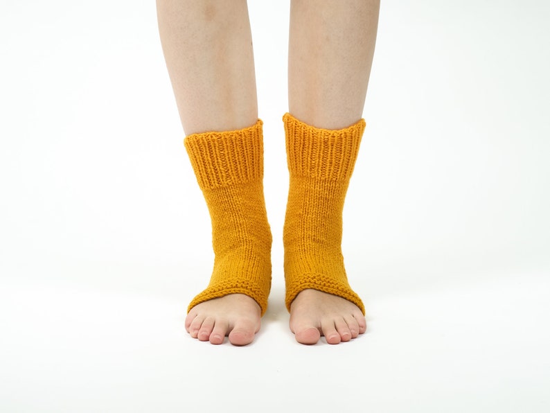 May include: A pair of yellow knitted ankle socks with open toes. The socks are made of a soft, warm material and are perfect for keeping your feet warm in the winter.