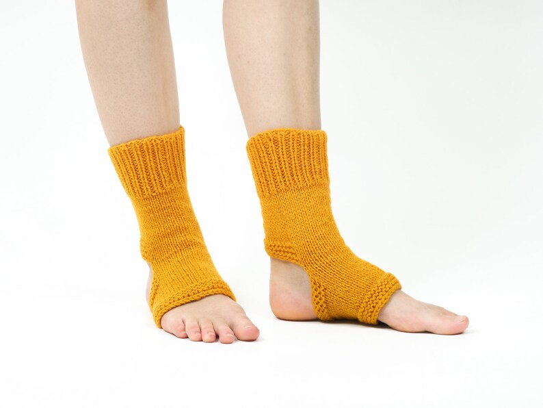 May include: A pair of yellow knitted ankle socks with an open heel design. The socks are made of a soft, comfortable material and are perfect for yoga or other activities.