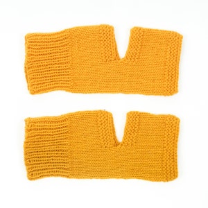 May include: A pair of yellow knitted arm warmers with a hole for the thumb.