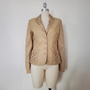 Front view of 1990s topstitched metal eyelet and stud embellished buff leather blazer by Donald Pliner, extra small to small.