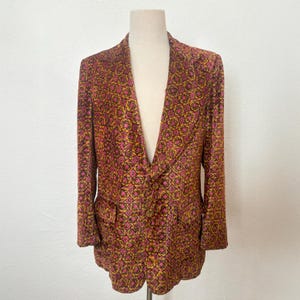 May include: A pink, yellow, and black patterned blazer with a notched collar and a single button closure.