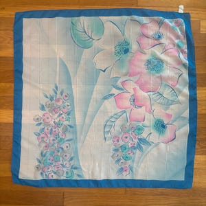 Vertical back view of 1980s vintage large pink, blue, and white floral print square sheer striped polyester scarf.