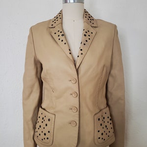 Front view of 1990s topstitched metal eyelet and stud embellished buff leather blazer by Donald Pliner, extra small to small.