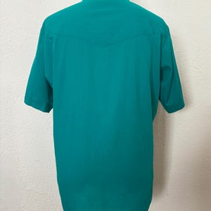Back view of 1980s vintage teal pearl snap short sleeve western shirt, by Sheplers, size medium to large.