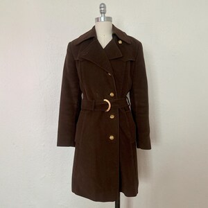 May include: A brown corduroy trench coat with a belt and gold buttons.