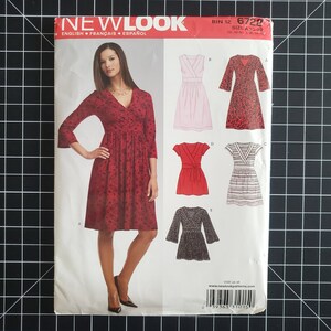 May include: A New Look sewing pattern featuring a woman in a red floral wrap dress. The pattern includes illustrations of various dress styles, including a pink dress, a red floral dress, a red wrap dress, a striped dress, and a black wrap dress.