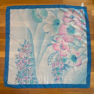 Horizontal back view of 1980s vintage large pink, blue, and white floral print square sheer striped polyester scarf.