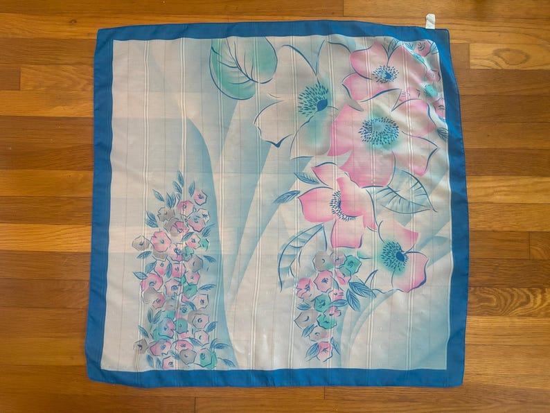 Horizontal back view of 1980s vintage large pink, blue, and white floral print square sheer striped polyester scarf.