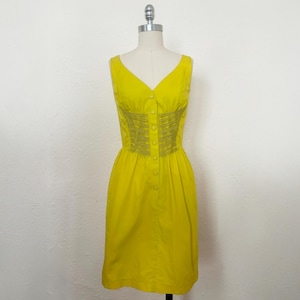 May include: A sleeveless yellow dress with a button-up front and a gathered waist.