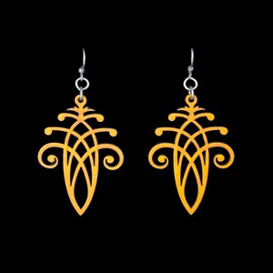 May include: A pair of gold-colored, ornate drop earrings. Each earring features a symmetrical design with swirling details and a teardrop shape. The earrings hang from silver-colored ear wires against a black background.
