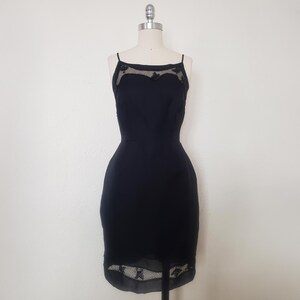 May include: A black slip dress with a lace trim around the neckline and hem.