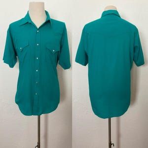 Front and back composite view of 1980s vintage teal pearl snap short sleeve western shirt, by Sheplers, size medium to large.