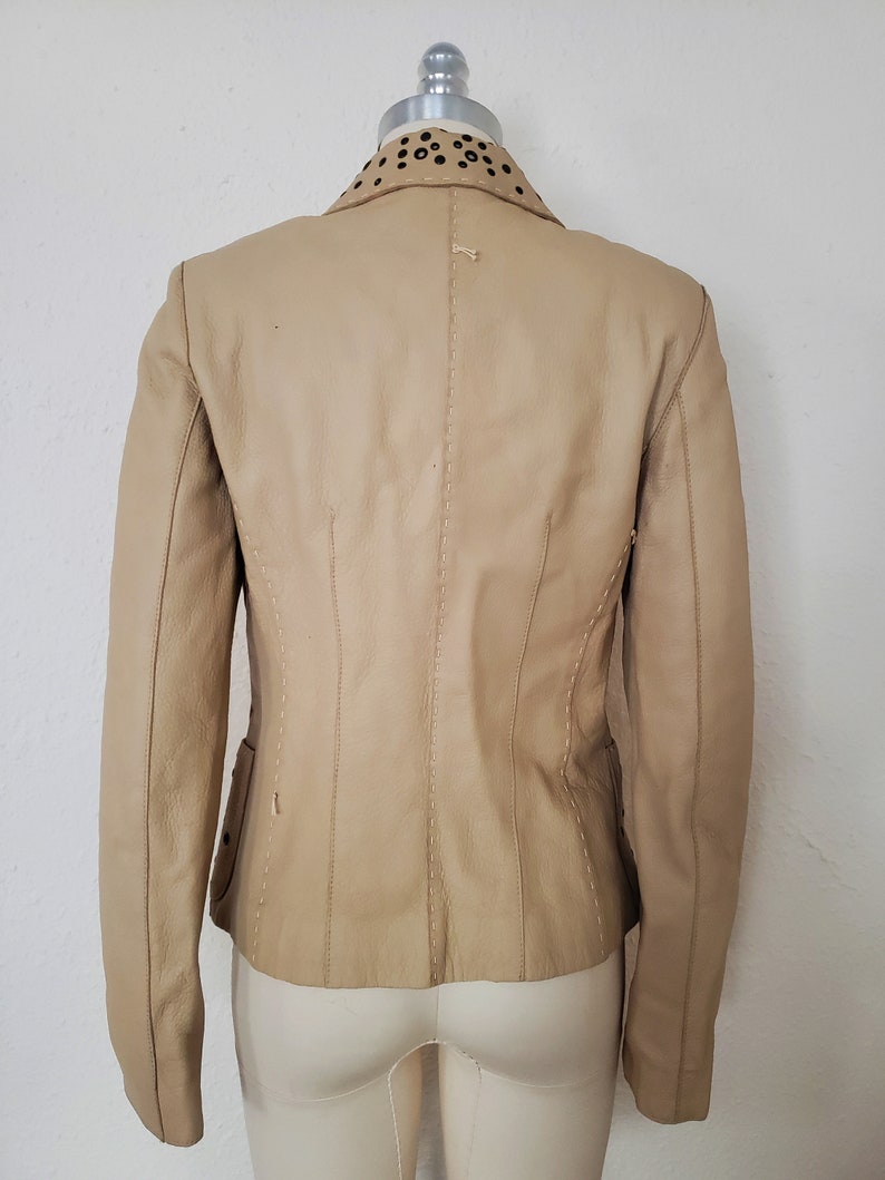 Back view of 1990s topstitched metal eyelet and stud embellished buff leather blazer by Donald Pliner, extra small to small