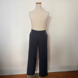 May include: Black dress pants with a straight leg design. The pants are displayed on a mannequin against a plain white background. The pants have a classic, tailored look.