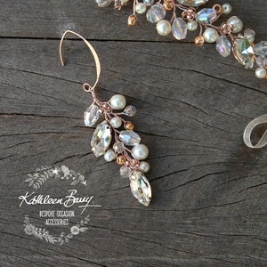 May include: A delicate rose gold hair comb with crystal and pearl accents. The comb is adorned with a cluster of clear crystals and white pearls, arranged in a cascading design. The comb is perfect for adding a touch of sparkle to any hairstyle.