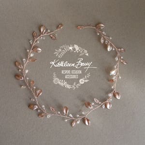 May include: Rose gold leaf hair vine with small white beads. The vine is made of wire and has a delicate, feminine look. It is perfect for adding a touch of sparkle to any hairstyle.