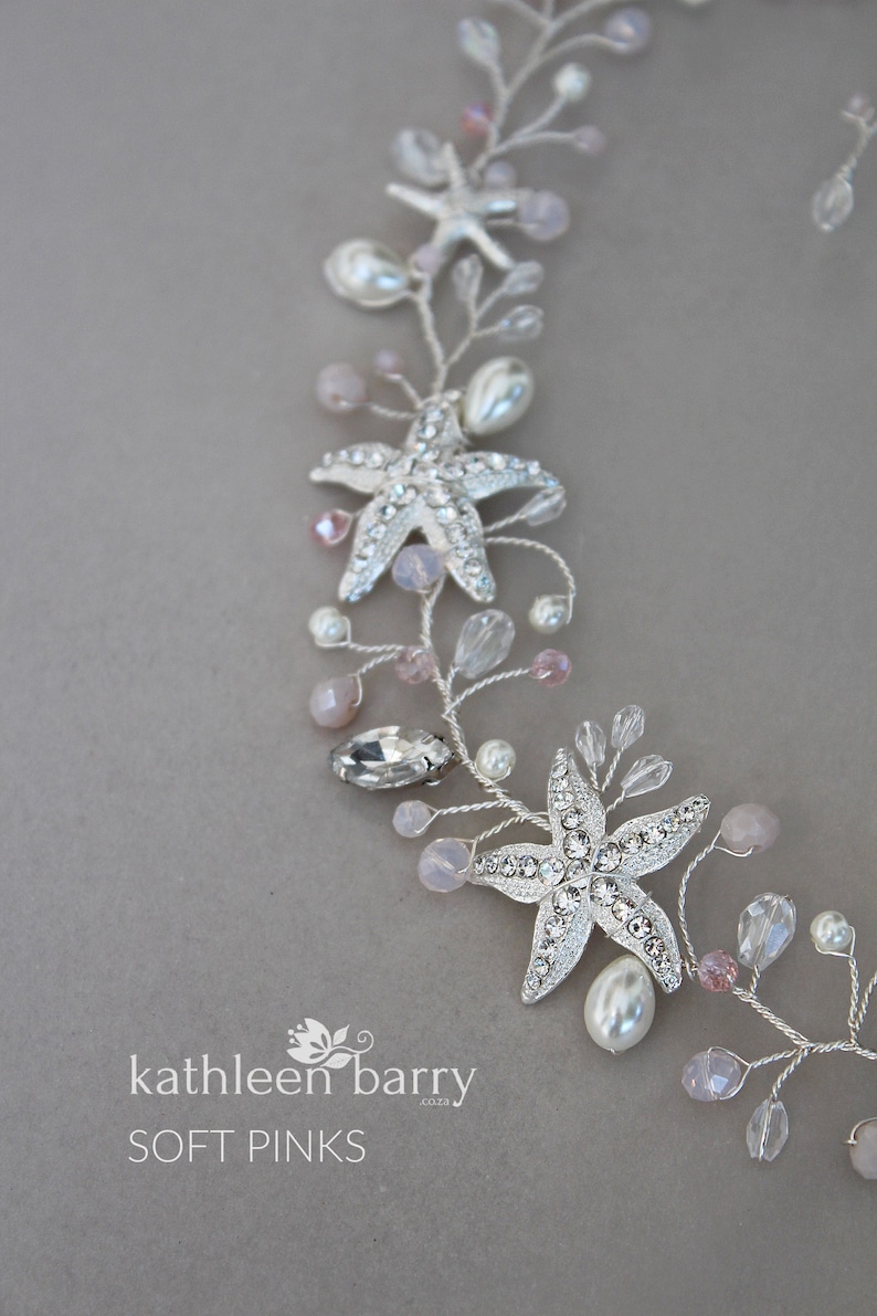 May include: A silver and pink beaded hair vine with starfish charms. The vine is decorated with small pearls and pink beads. The text "kathleen barry co. 2023 SOFT PINKS" is visible at the bottom of the image.