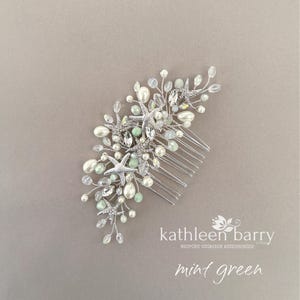 May include: A silver hair comb featuring multiple starfish charms, white faux pearls, clear crystals, and small mint green beads arranged on thin silver wire branches. The text kathleen barry and mint green is visible in the lower right corner.