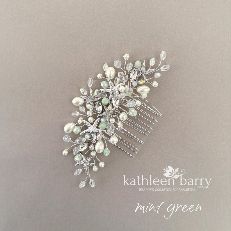 May include: A silver hair comb featuring multiple starfish charms, white faux pearls, clear crystals, and small mint green beads arranged on thin silver wire branches. The text kathleen barry and mint green is visible in the lower right corner.