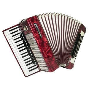 May include: A red and black accordion with a keyboard and bellows. The accordion has a glossy finish and the brand name "Weltmeister" is visible. The keys are black and white, and the bellows are a burgundy color.