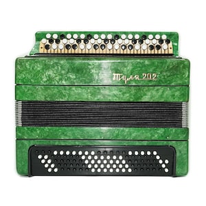 May include: A green accordion with black bellows and a keyboard of white and black buttons. The instrument has a textured finish and the text "Тула 202" is visible on the front. The accordion is a musical instrument.
