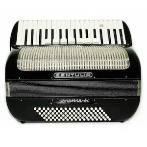 May include: A black accordion with a silver trim and the word "CANTULIA" in silver lettering on the front. The accordion has a white keyboard and a black and white bellows.