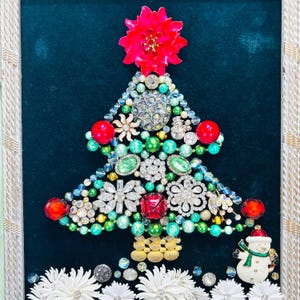 May include: A Christmas tree crafted from rhinestones, beads, and other jewellery. The tree is adorned with red, green, and white decorations. A snowman figurine sits at the base of the tree.