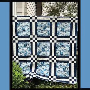 May include: A quilt pattern titled Willow by Tricia Lynn Maloney for Orphan Quilt Designs and Villa Rosa Designs. The quilt features a grid of blue and white patterned fabric squares separated by dark navy blue and white solid fabric strips.