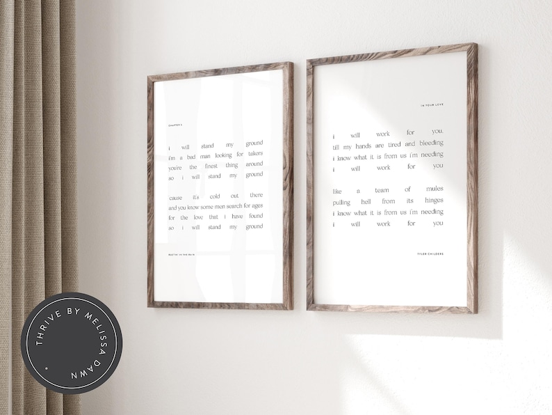 May include: Two framed art prints with black text on a white background. The prints have a wooden frame. The text includes song lyrics. The prints are displayed on a white wall.