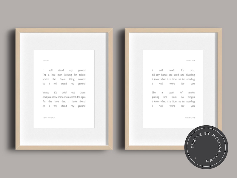 May include: Two framed prints with beige frames, each displaying black text on a white background. The left print features a poem titled "Chapter 4", while the right print has a poem titled "In Your Eyes". A black circular logo is in the bottom right corner.