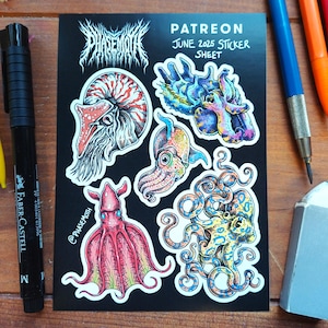 Könnte beinhalten: Ein schwarzes Stickerbogen mit detaillierten Illustrationen von Meereslebewesen, darunter ein Oktopus, ein Tintenfisch und ein Nautilus. Das Blatt trägt den Text "PATREON JUNE 2025 STICKER SHEET" und den Namen des Künstlers. Ein schwarzer Marker, Bleistifte und ein Radiergummi sind ebenfalls sichtbar.